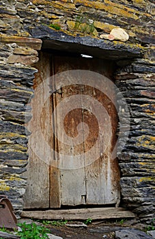 Typical old stone house and wooden door in Ushguli