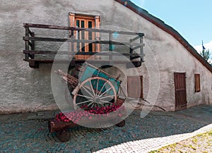 typical outdoor house in mountain with flowerpot with purple flower, blue old wood gig, window and balcony in pragelato italy