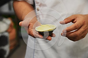 Hand of baker preparing traditional Portuguese custard tart, pastel de nata photo