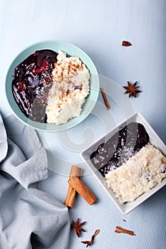 Typical Peruvian dessert: rice pudding and purple mazamorra on a light blue background.