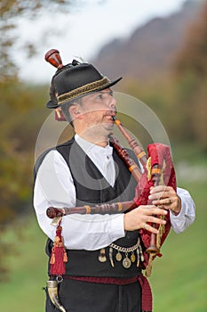 Typical player in traditional northern Italy bagpipe costume, an