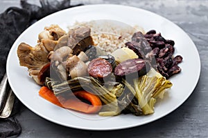 Typical portuguese dish boiled meat, smoked sausages, vegetables and rice on white plate