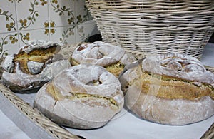 Typical Portuguese Easter cakes, also called Folar or folares, with traditional portuguese tiles in background.