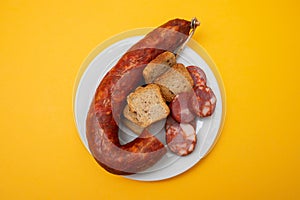 typical portuguese smoked sausage chourico on white plate
