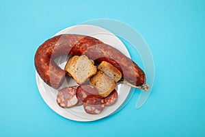 typical portuguese smoked sausage chourico on white plate