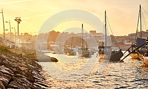 Typical portuguese wooden boats, called  `barcos rabelos  `transporting wine barrels on the river Douro with view on Villa Nova de photo