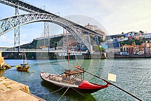 Typical portuguese wooden boats, called `barcos rabelos ` transporting wine barrels on the river Douro with view on Villa Nova de photo
