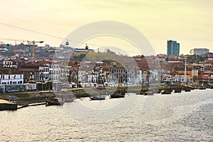 Typical portuguese wooden boats, called `barcos rabelos `transporting wine barrels on the river Douro with view on Villa Nova de G photo