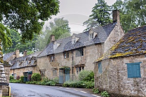 Typical pretty cottages with climbing plants with yellow Cotswold limestone walls in Snowshill, Cotswolds - England