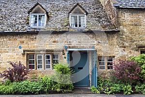 Typical pretty cottages with climbing plants with yellow Cotswold limestone walls in Snowshill, Cotswolds - England