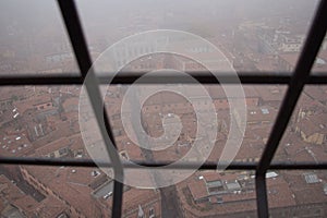 Typical red roofs of Bologna in a foggy day. View from a narrow window of Asinelli Tower. Emilia Romagna , Italy.