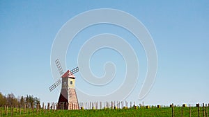 The typical red windmill standing in the fields. The rural landscape