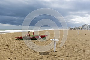 A typical red wooden rescue boat on the beach of Rimini, Italy, during a winter storm