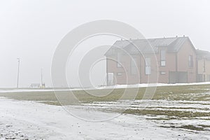 typical residential building in fog in early spring in Finland