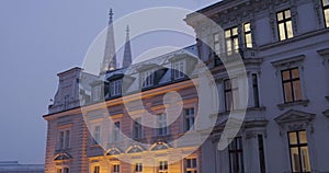 Typical residential buildings in Vienna, Austria, illuminated during Winter evening with light snow. Architecture, house, home.