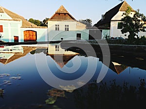 Typical Romanian ancient houses reflected on the water