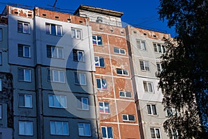 typical russian ugly high rise apartmant building with russian national flags in some windows at summer day