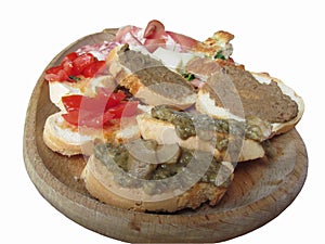 Typical rustic tuscan appetizer with crostini, prosciutto, brawn, salami cheese on a wooden tray Italian starter isolated on white
