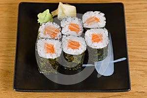 Typical salmon sushi roll, served with gari and wasabi