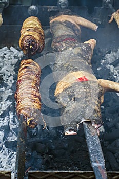 Typical Sardinian food. Piglets roast and entrails of animals roast cooking in the bbq in a typical sardinian community festival