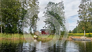 A typical scandinavian red wooden cottage on the shores of lake Saimaa in Finland