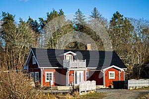 Typical Scandinavian Swedish red wooden house. Road. Countryside authentic cozy old house in rural area