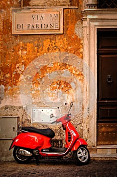 Typical scene with a red scooter on a narrow central Rome street photo