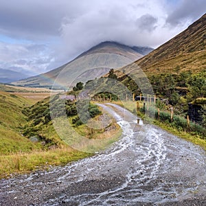 Typical Scottish landscape with heavy clouds and rainbow