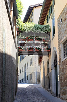 Typical small alley with flowers in upper city Citta Alta of Bergamo