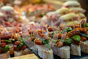 Typical snack of Basque Country and Navarre, pinchos or pinxtos, small piece of bread with different toppings, served in bar,