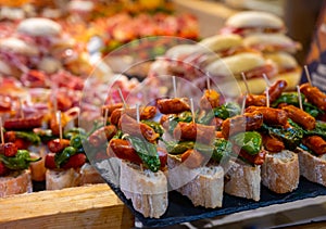 Typical snack of Basque Country and Navarre, pinchos or pinxtos, small piece of bread with different toppings, served in bar,