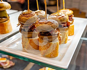 Typical snack of Basque Country, pinchos or pinxtos skewers with small pieces of bread, mushrooms and meat served in bar in San-