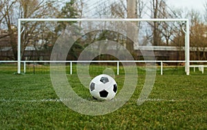 Typical soccer ball on the free kick marking line in front of stadium gate. Traditional football ball on the green grass turf