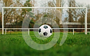 Typical soccer ball on the free kick marking line in front of stadium gate. Traditional football ball on the green grass turf