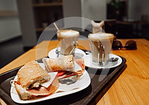 Breakfest snack - coffee latte and bocadillo sandwich on table in one cafe photo