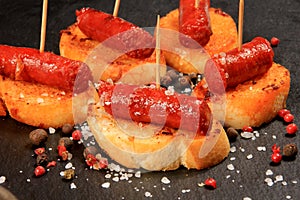 Typical spanish chorizo tapas. Pork sausage called chistorra on bread.