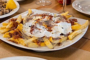 Typical Spanish food, fried eggs, chips and ham. Scrambled eggs photo