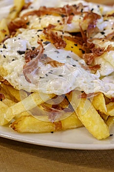 Typical Spanish food, fried eggs, chips and ham. Scrambled eggs photo