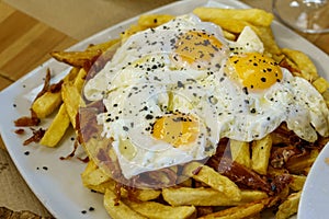 Typical Spanish food, fried eggs, chips and ham. Scrambled eggs photo