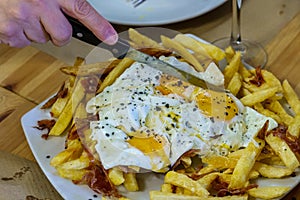 Typical Spanish food, fried eggs, chips and ham. Scrambled eggs photo