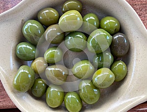 Typical spanish olives on beige plate