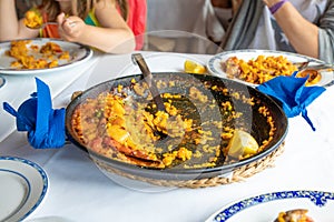 Typical Spanish paella pan served with big spoon in restaurant