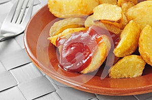 Typical spanish patatas bravas, fried potatoes with a hot sauce photo