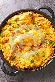 Typical spanish rice with rabbit arroz con conejo closeup in the pan. Vertical top view photo