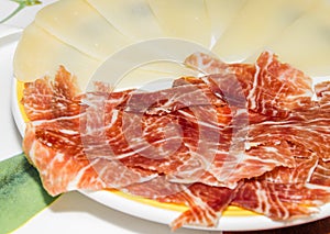 Typical spanish tapa with slices of serrano ham and manchego che