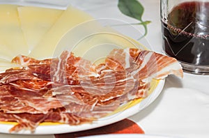 Typical spanish tapa with slices of serrano ham and manchego che