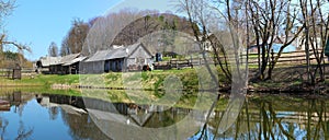 A typical spring April rural Lithuanian landscape is a cold lake coast with wooden barn and fores