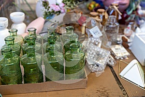 Typical stall on Els Encants flea market at Placa de les Gloriesa. Nine green figured juice or perfume bottles among sewing photo