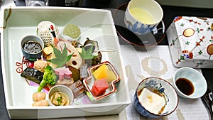 Typical starter in Japan with raw fish, prawns, tofu, seaweed and vegetables, fruits beautifully arranged in Japanese porcelain.