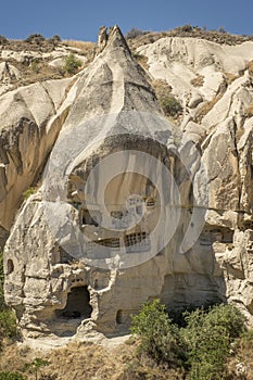 Typical stone dwelling carved in the fairy chimneys with dovecotes carved in the volcanic rock, rock hoodoo in Goreme, Cappadocia